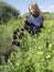 Blonde girl looks at flowers Iris in the protected natural area