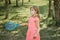 A blonde girl in a medical mask with a blue badminton racket in her hands.