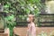 Blonde girl in a medical mask looks at insects at the zoo. Exhibition farm of live tropical butterflies in the Exhibition Center