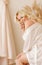 Blonde girl plus size sitting on the bed in white lingerie portrait of Bali morning bride