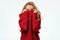 Blonde girl pulling red sweater over head being scared.