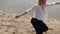 Blonde girl sensually dancing on a background of the sea in white and black clothes