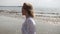 Blonde girl sensually dancing on a background of the sea in white clothes