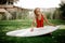 Blonde girl sitting on her knees holding the wakeboard