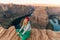 Blonde girl sitting Horseshoe Bend in Glen Canyon National Recreation Area in early dawn