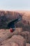 blonde girl sitting Horseshoe Bend in Glen Canyon National Recreation Area in early dawn