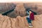 blonde girl sitting Horseshoe Bend in Glen Canyon National Recreation Area in early dawn