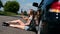 Blonde girl sitting on road near her broken car