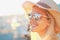 A blonde girl smiling with hat on - Beach and sunlight reflected in sunglasses - Beautiful young women in holidays - Portrait