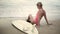 Blonde girl with surfboard on beach