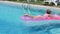 Blonde girl swims in the pool on an inflatable mattress