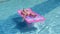 Blonde girl swims in the pool on an inflatable mattress