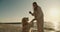 A blonde girl trains her big dog, light coloring, with new commands, plays with her in the morning on a sunny beach