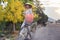 blonde girl in Vietnamese dress and hat near bike on street