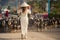blonde girl in Vietnamese dress watches goats flock