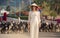 blonde girl in Vietnamese dress watches goats flock