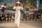 blonde girl in Vietnamese dress watches goats flock