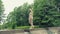 A blonde girl walks across the bridge from which water flows. Natural beauty.