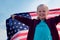 Blonde girl waving national USA flag outdoors over blue sky at summer - american flag, country, patriotism, independence