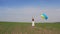 A blonde girl is waving Ukrainian flag on nature background in sunny day