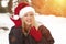 Blonde Girl Wearing Santa Hat and Gloves Outdoors in Snow