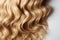 Blonde hair perfection A curly strand stands out on white