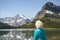 Blonde hair woman looking at the mountain landscape of Montana. 70 year old tourist looking at beautiful mountains of Glacier
