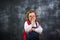 Blonde happy schoolgirl makes funny faces against blackboard. Back to school. Primary pupil ready for education