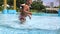 Blonde little girl bathes in city swimming pool