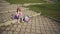 Blonde little girl eating her lunch in park on sunny day.