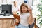 Blonde little girl at pediatrician clinic with female doctor surprised with an idea or question pointing finger with happy face,