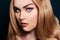 Blonde with long hair looking at the camera. Professional makeup, beautiful eyebrows, white lenses. Looking vampires, bright eyes