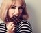 Blonde makeup woman eating dark chocolate with look. Short