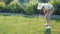 A blonde middle-aged woman gardener puts arches in the ground for a garden bed