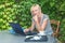 Blonde middle aged woman is sitting in outdoor office