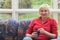 Blonde middle-aged woman is sitting on a sofa