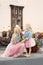 Blonde mom and little daughter in pink skirts and denim shirts look at each other. Mother`s day