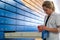 Blonde pharmacist checking a medical product and precription in one of the alphabetical pharmacy drawers