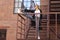 The blonde practices yoga on a metal staircase