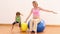 Blonde pregnant woman sitting on exercise ball with her little girl