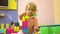Blonde preschool toddler playing with multi coloured building blocks in kindergarten. Child development in nursery