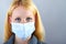 Blonde serious woman with surgical mask
