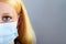 Blonde serious woman with surgical mask