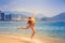 blonde slim girl in bikini jumps on beach
