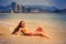 blonde slim girl in bikini lies on back in edge of sea smiles