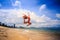Blonde slim gymnast in bikini in jump over beach against sky