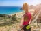 Blonde sport woman in sportwear running on mountain path. Summer vacations in Greece