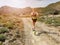 Blonde sport woman in sportwear running on mountain path. Summer vacations in Greece