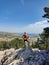 Blonde sport woman in sportwear running on mountain path. Summer vacations in Greece