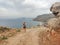 Blonde sport woman in sportwear running on mountain path. Summer vacations in Greece